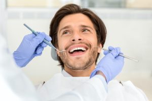Portrait of handsome smiling man attending dentist