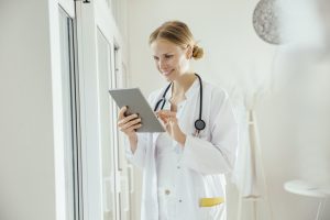 Smiling female doctor using digital tablet